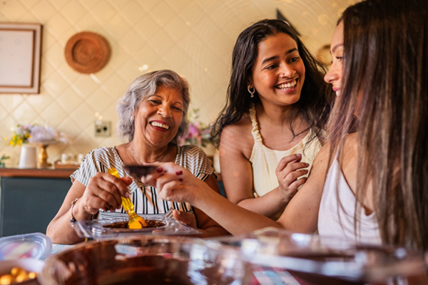 Three Latina women sharing a meal and conversation together
