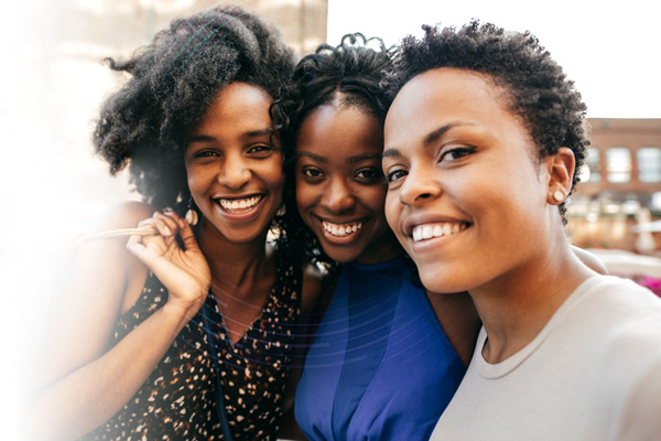 Three Black women smiling together